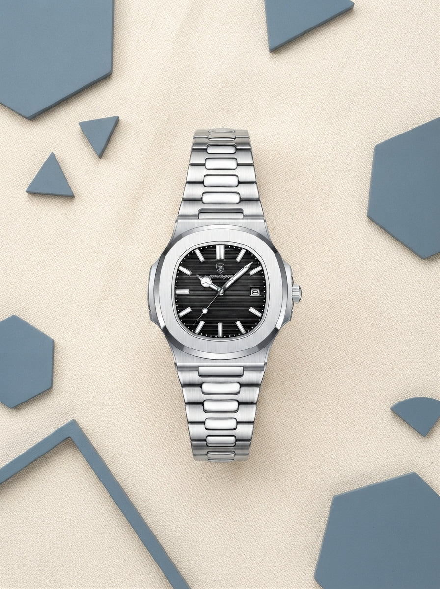 A luxury stainless steel watch displayed on a warm cream surface with slate blue accents, showcasing a minimalist and profess