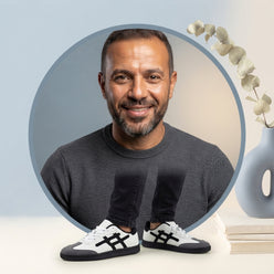 Portrait of Omar Hassan wearing comfortable Anjrs running shoes, set against a clean, minimalist background.