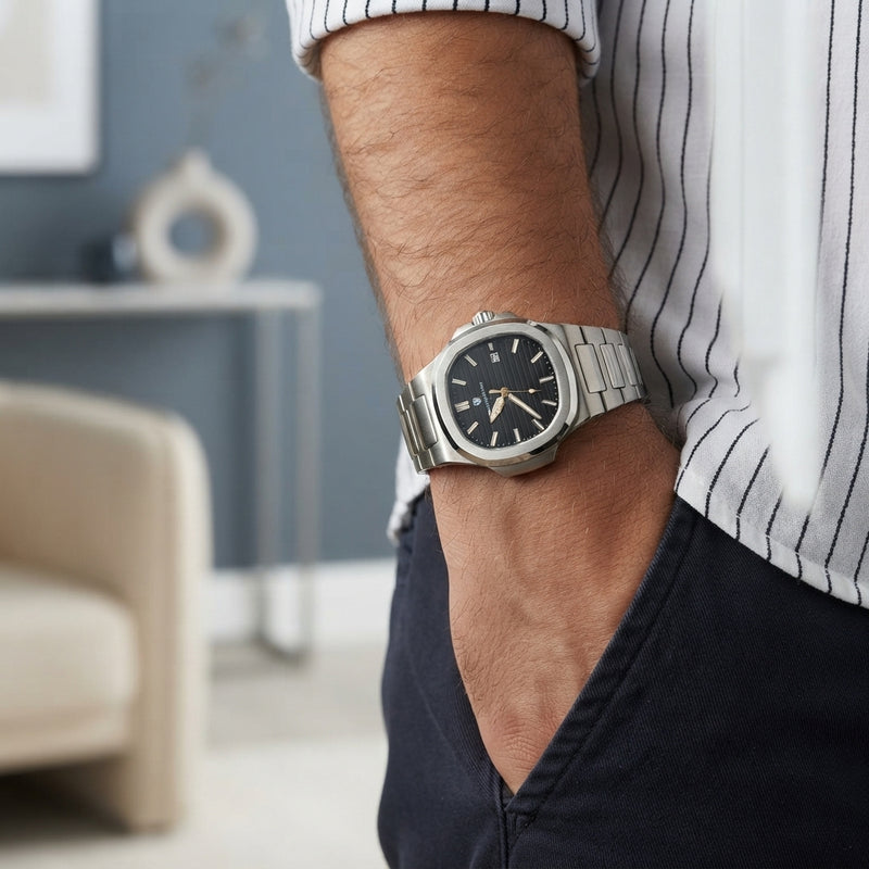 Close up of a luxury stainless steel watch showing the detailed brushed metal finish on a person's wrist.